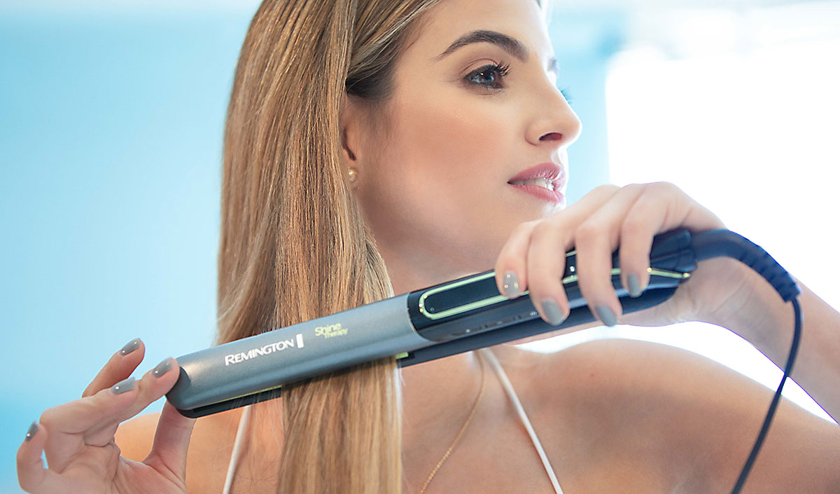 Mujer alisando cabello con plancha Remington