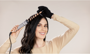 Mujer riza su cabello con el rizador CI23AW de la línea Collagen & Biotin de Remington.